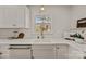 Bright kitchen with white cabinets, stone countertops, stainless appliances, and a farmhouse sink at 6215 Coatbridge Ln, Charlotte, NC 28212