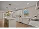 Bright kitchen with white cabinets, a center island with seating, gold hardware, and pendant lighting at 6215 Coatbridge Ln, Charlotte, NC 28212