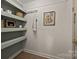 Pantry with painted shelves, accent wall, and view to outside at 6215 Coatbridge Ln, Charlotte, NC 28212