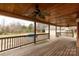 Expansive wood back porch with a ceiling fan and railing, offering a view of the large backyard and pool area at 705 Tirzah Rd, York, SC 29745