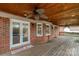 Spacious covered wood back porch featuring a ceiling fan, brick pillars, and access to the pool area at 705 Tirzah Rd, York, SC 29745