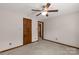 Neutral bedroom showcases carpet, ceiling fan, baseboard trim, and wood door at 705 Tirzah Rd, York, SC 29745