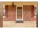 Inviting front entrance featuring a glass storm door, red brick accents, and decorative shutters at 705 Tirzah Rd, York, SC 29745