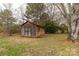 Exterior view of shed with wood siding and double doors, nestled among trees in a backyard at 705 Tirzah Rd, York, SC 29745