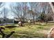 Expansive backyard featuring playground, lawn, and treelined landscape at 7562 Sedgebrook W Dr, Stanley, NC 28164