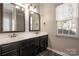 Bathroom featuring a double sink vanity with dark cabinetry and granite countertops at 7562 Sedgebrook W Dr, Stanley, NC 28164