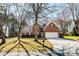 Classic brick facade home with a well-kept lawn, complemented by mature trees adding shade and character at 7562 Sedgebrook W Dr, Stanley, NC 28164