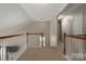 Bright hallway featuring wood railing and neutral walls at 7562 Sedgebrook W Dr, Stanley, NC 28164