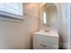 A half bathroom has a white vanity and a round mirror at 8247 Pozzi Rd, Charlotte, NC 28216