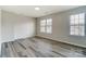 Bright bedroom with two windows providing lots of natural light and light gray vinyl floors at 8247 Pozzi Rd, Charlotte, NC 28216