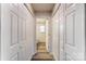 Hallway with multiple closets leading to a bathroom, showing the home's storage and layout at 8247 Pozzi Rd, Charlotte, NC 28216