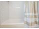 Clean white bathtub with subway tile surround and neutral-toned shower curtain at 9613 Central Dr, Mint Hill, NC 28227