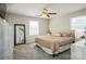 Bright bedroom featuring a ceiling fan, large mirror, and two windows for natural light at 9613 Central Dr, Mint Hill, NC 28227