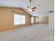 Spacious carpeted bedroom with a vaulted ceiling, ceiling fan, and two windows at 9684 Ravenscroft Nw Ln, Concord, NC 28027