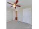 Neutral bedroom showcasing a ceiling fan, carpet, and two doors, offering a simple and comfortable space at 9684 Ravenscroft Nw Ln, Concord, NC 28027