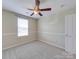 Neutral bedroom featuring a ceiling fan, window, and carpeting, creating a comfortable and inviting space at 9684 Ravenscroft Nw Ln, Concord, NC 28027