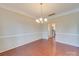 Bright dining area showcasing hardwood floors, chandelier, and open access to the kitchen at 9684 Ravenscroft Nw Ln, Concord, NC 28027