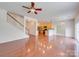 Open concept living room featuring hardwood floors, staircase, and seamless flow into kitchen at 9684 Ravenscroft Nw Ln, Concord, NC 28027