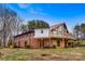 View of the exterior showcasing the large deck, patio, and mature trees at 1109 Hemlock Dr, Shelby, NC 28150