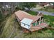 Aerial view of home showcasing large deck, expansive windows, and mature trees at 1109 Hemlock Dr, Shelby, NC 28150