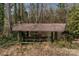 Gazebo in wooded area with overgrown landscaping and picnic table at 1109 Hemlock Dr, Shelby, NC 28150