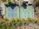 Aerial view of multiple outdoor tennis courts surrounded by lush trees, with cars parked nearby at 11122 Windgate Ct, Tega Cay, SC 29708