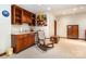 Basement bar featuring custom wood cabinets, granite countertops, a small sink, and a mini refrigerator at 11122 Windgate Ct, Tega Cay, SC 29708