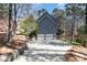 Long driveway leading to a three-car garage, with a sloping, wooded backyard at 11122 Windgate Ct, Tega Cay, SC 29708