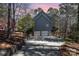 Side view of a two-story home with gray siding, three-car garage, and natural landscaped surroundings at 11122 Windgate Ct, Tega Cay, SC 29708