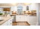 Well-lit kitchen with white cabinets, granite countertops, and a large window overlooking the outdoors at 11122 Windgate Ct, Tega Cay, SC 29708