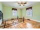 Empty bedroom with hardwood floors, two windows, and ceiling fan at 12 Roberta Rd, Concord, NC 28027