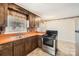 Functional kitchen featuring retro countertops and stainless steel appliances at 12 Roberta Rd, Concord, NC 28027