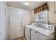 Bright laundry room featuring white appliances and wood-paneled walls and ceiling at 12 Roberta Rd, Concord, NC 28027