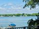 Beautiful lake view featuring a boat under a blue cover on a lift in front of a treelined shore with blue sky at 121 Kelly Point Ln, Mooresville, NC 28117