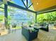 Relax on this covered patio featuring comfortable seating and stunning lake views, perfect for outdoor living and entertaining at 121 Kelly Point Ln, Mooresville, NC 28117