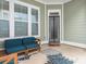 A view of the back porch with blue cushions on a wood frame sofa and chairs at 12432 Bradford Park Dr, Davidson, NC 28036