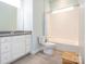 Bright bathroom featuring white cabinets, stone countertop, and a shower-tub combo at 12432 Bradford Park Dr, Davidson, NC 28036