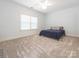 Neutral bedroom with soft carpet, large window, and bed covered by a blue blanket at 12432 Bradford Park Dr, Davidson, NC 28036