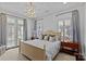 Spacious bedroom with a decorative chandelier, neutral color palette, and French doors leading to the outside at 1414 Biltmore Dr, Charlotte, NC 28207