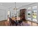 Dining space with wood table and chairs, view to kitchen and double doors to the exterior at 1414 Biltmore Dr, Charlotte, NC 28207