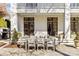 Charming outdoor dining area with a large stone patio and a white balcony above at 1414 Biltmore Dr, Charlotte, NC 28207