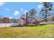 Spacious fenced backyard with green grass, wooden deck, and mature trees at 1417 Shady Bark Dr, Gastonia, NC 28054