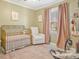 Charming Bedroom featuring a golden crib, comfortable seating, and soothing décor at 1417 Shady Bark Dr, Gastonia, NC 28054