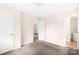 This bedroom features neutral walls and carpet flooring, alongside a door opening to another room at 1502 Northwoods Dr, Kings Mountain, NC 28086