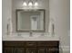 Bathroom with double sink vanity, silver framed mirror and overhead lighting at 17809 Pawleys Plantation Ln, Charlotte, NC 28278