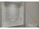 Tub and shower combo featuring built in shelves and brushed aluminum hardware at 17809 Pawleys Plantation Ln, Charlotte, NC 28278