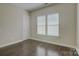 Simple bedroom features two windows, hardwood floors, base molding, and neutral paint at 17809 Pawleys Plantation Ln, Charlotte, NC 28278