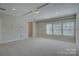 A bright, spacious carpeted bedroom with tray ceiling, recessed lighting, and multiple windows at 17809 Pawleys Plantation Ln, Charlotte, NC 28278