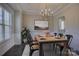 Elegant dining room featuring a rustic wood table, stylish chandelier, and natural light from the window at 17809 Pawleys Plantation Ln, Charlotte, NC 28278