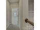 Bright hallway with carpet leading to a bedroom, featuring a wooden handrail at 17809 Pawleys Plantation Ln, Charlotte, NC 28278